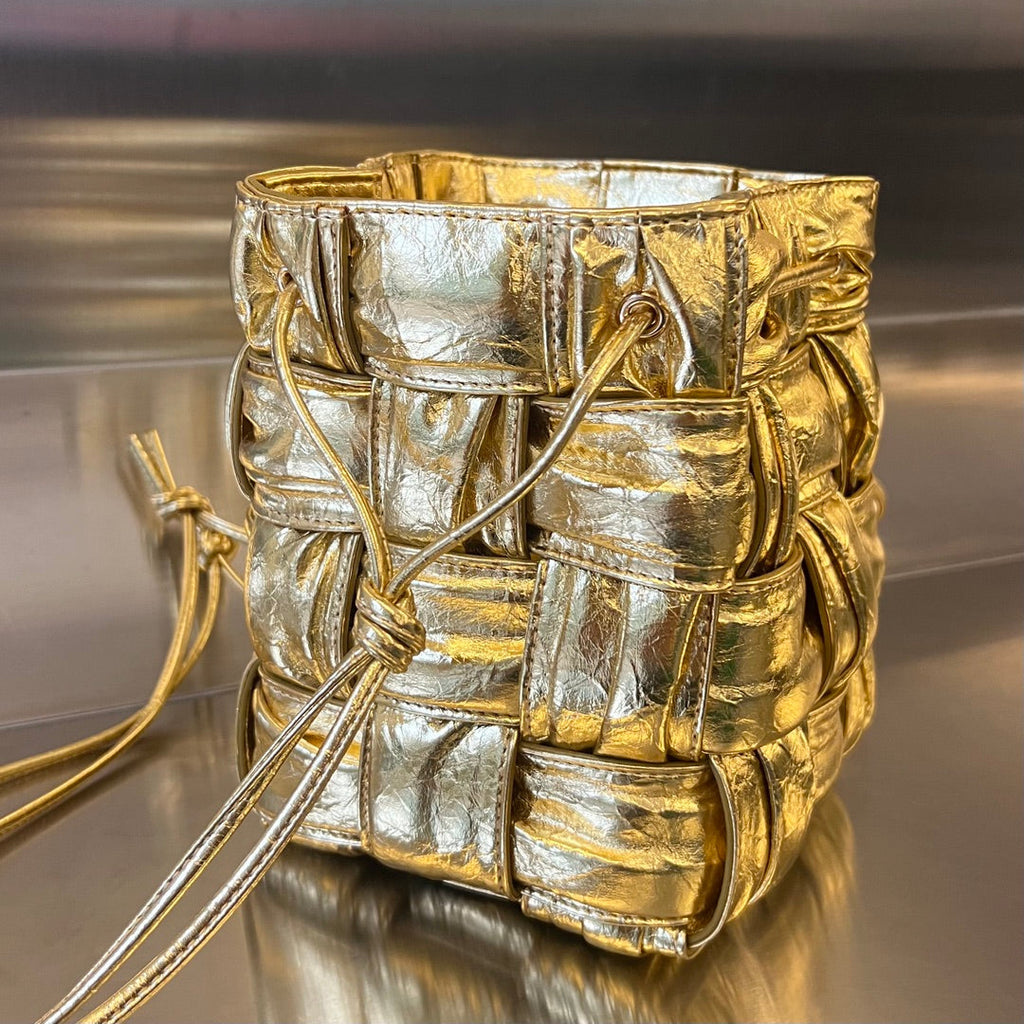 BOTTEGA VENETA SMALL CASSETTE BUCKET 18 IN GOLD METALLIC SOFT LAMBSKIN