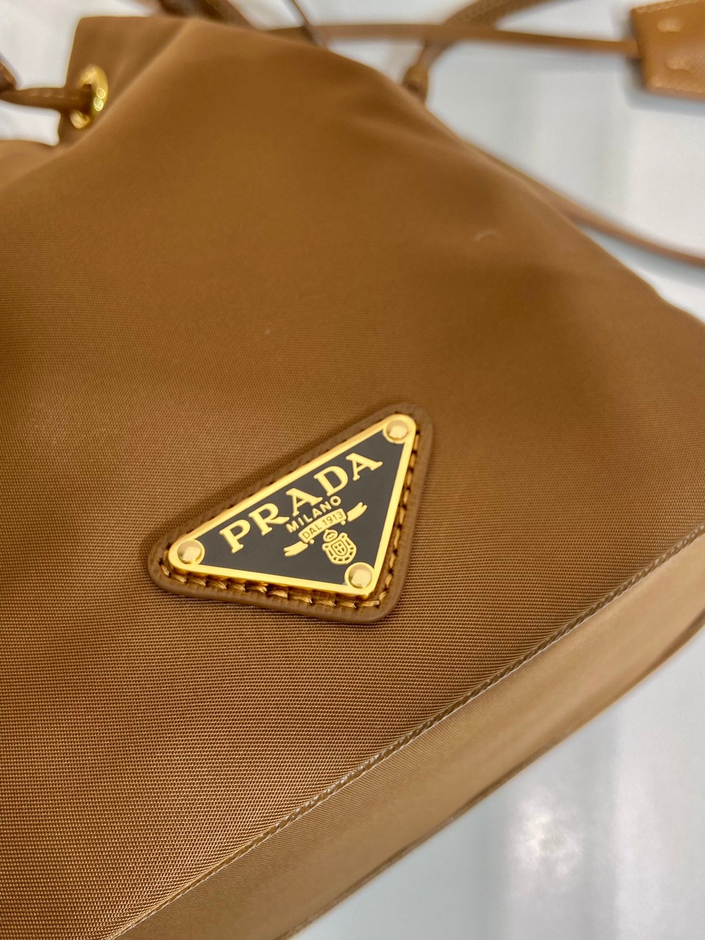 PRADA BUCKET BAG 19 IN RUSSET BROWN RE-NYLON AND CALFSKIN HANDLE