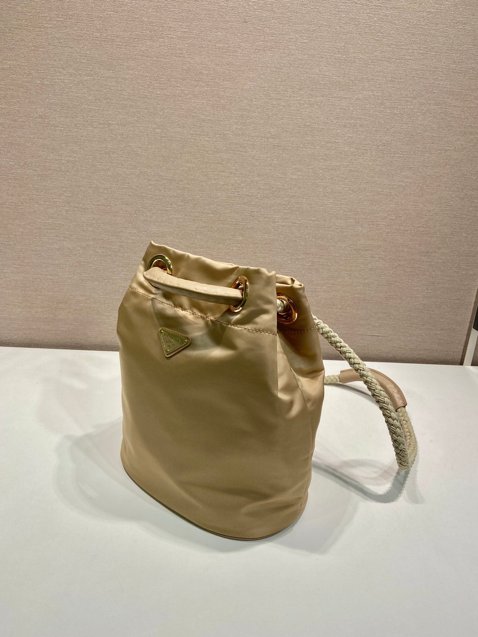 PRADA BUCKET BAG 28 IN BEIGE RE-NYLON GOLD LOGO
