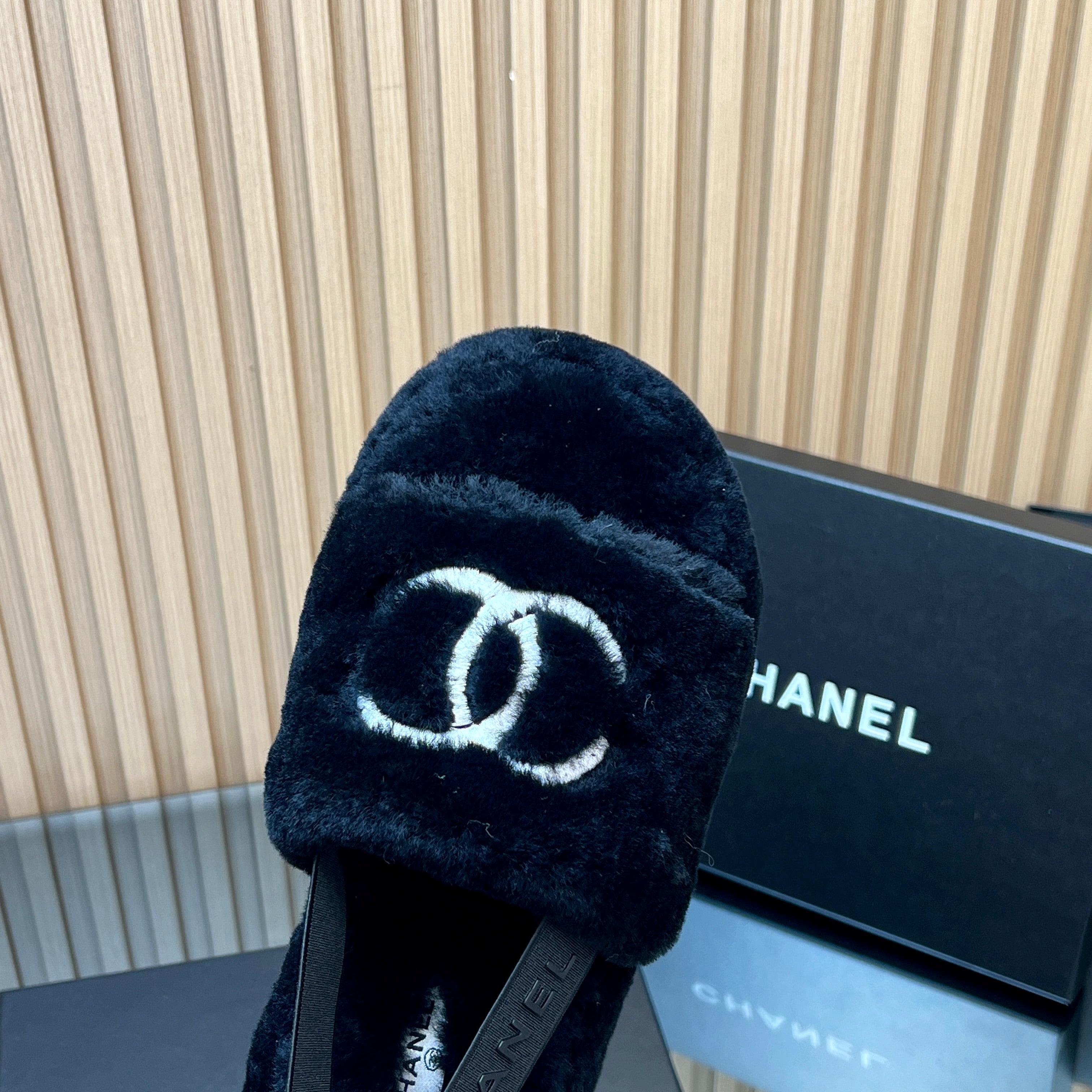 CHANEL 25S THICK-SOLED FURRY SLIPPERS WITH ELASTIC STRAPS IN BLACK FUR