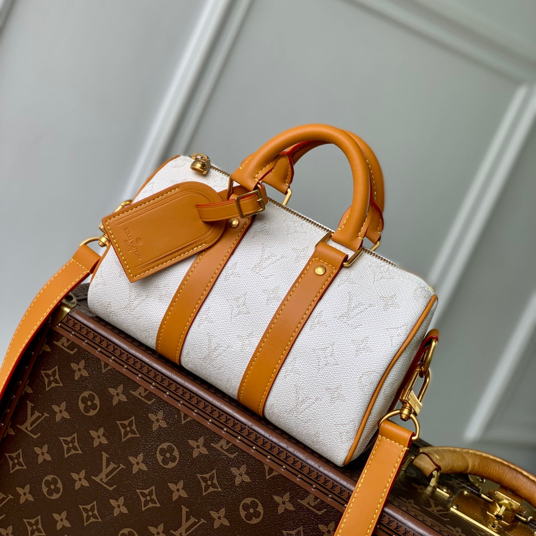 LOUIS VUITTON KEEPALL BANDOULIÈRE 25 IN WHITE MONOGRAM HERITAGE CANVAS BRWON CALFSKIN