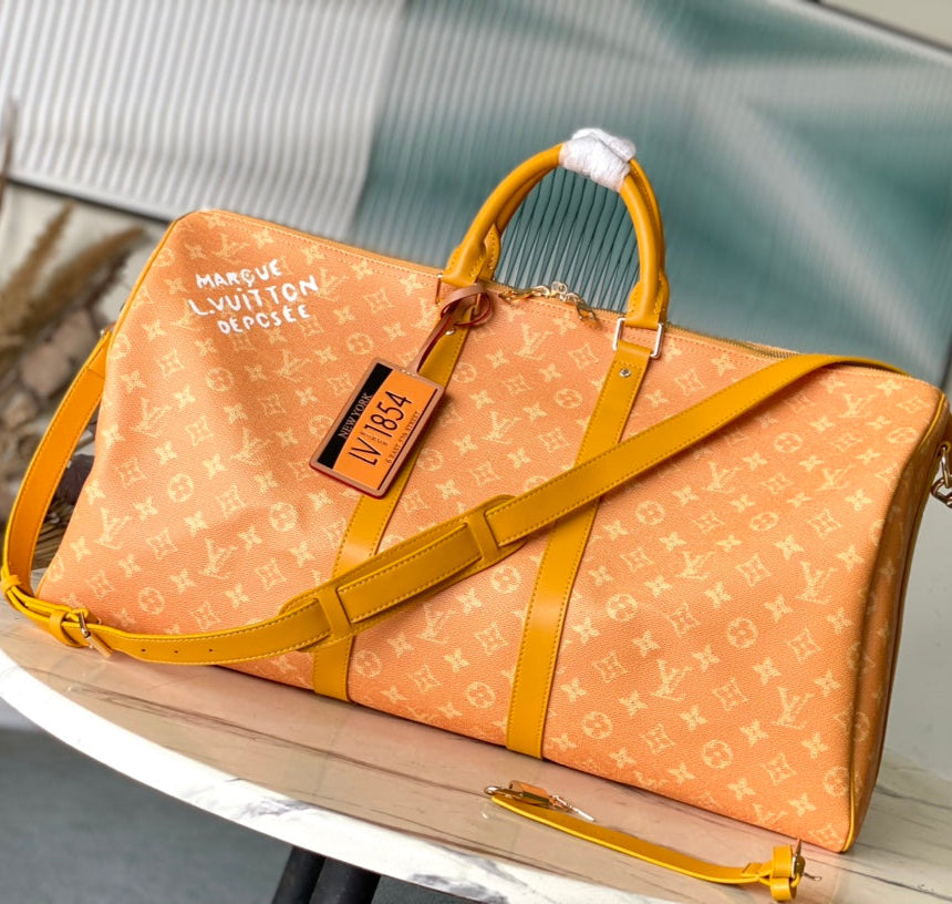 LOUIS VUITTON KEEPALL BANDOULIÈRE 55 IN ORANGE MONOGRAM HERITAGE CANVAS